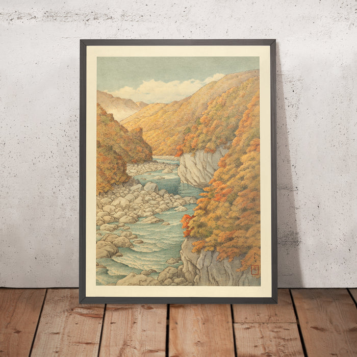 A framed image of Autumn Trees and Rocky River by Hasui Kawase, 1935