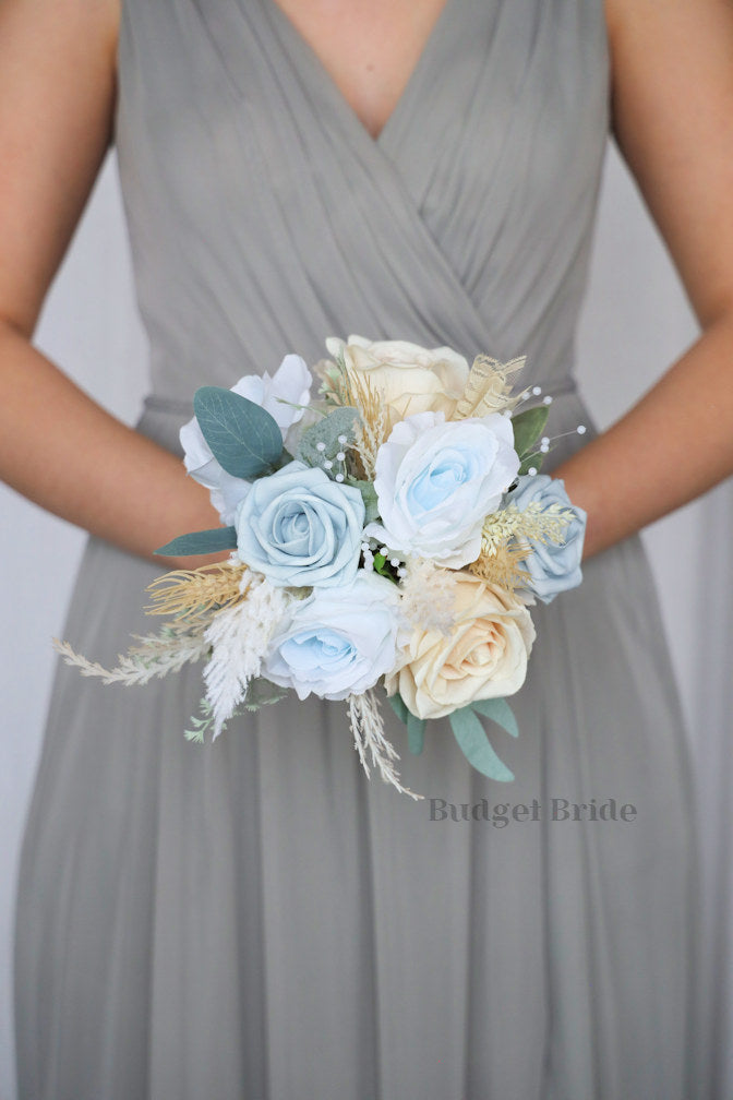 White tiger lilies, dusty blue and peach roses, pearls, pampas grass and wheat in artificial flower brides bouquet