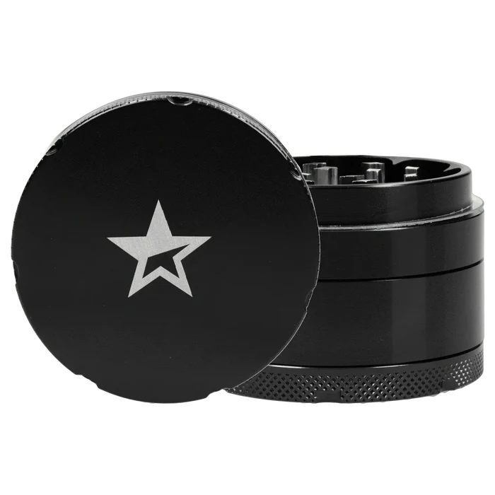 Close-up three-quarter view of the Famous X 4 pc Grinder -Black - 50mm showing the black top with a silver star logo and textured knurled base.