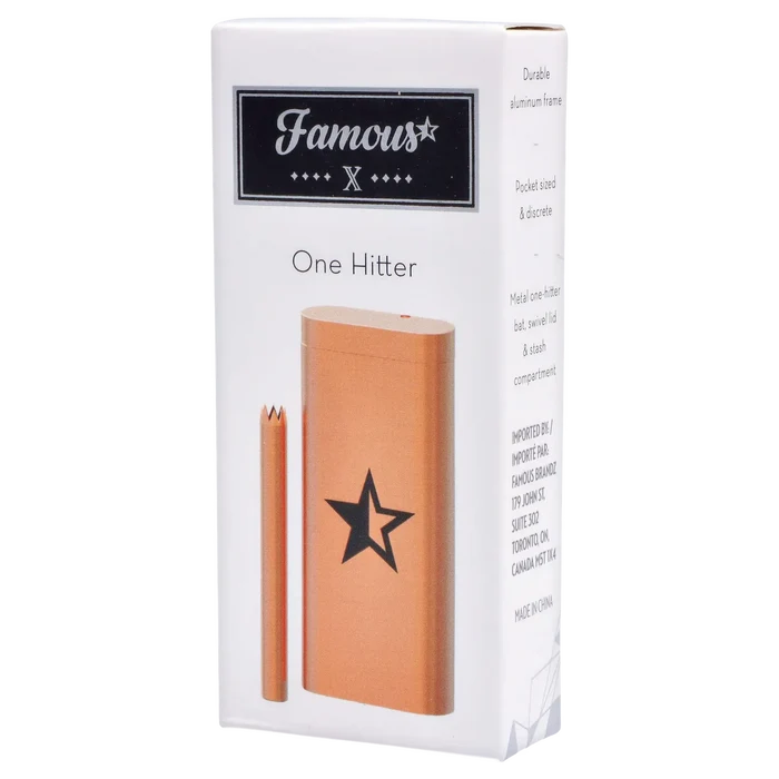 Angled front view of the Famous X Aluminum Dugout - Rose Gold showing the rose-gold metal case and matching bat against a white box.