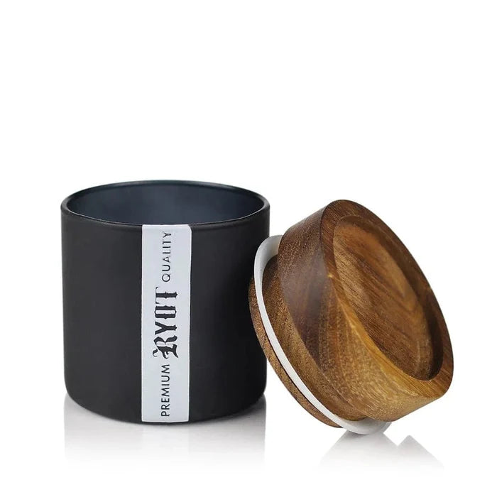 RYOT Glass Jar with Tray Lid shown in a close-up, angled view with the lid slightly ajar on a reflective surface.